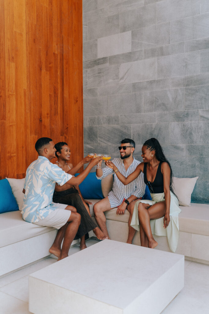 Group of friends toasting together in an outdoor villa lounge