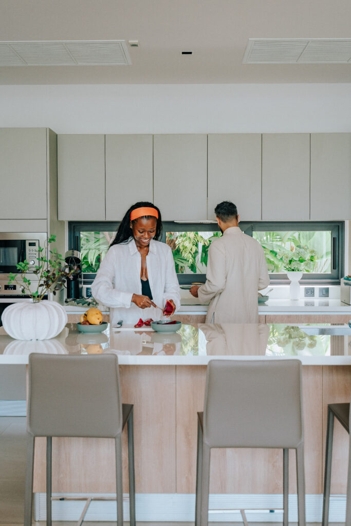 Couple cooking together in a modern, luxurious kitchen