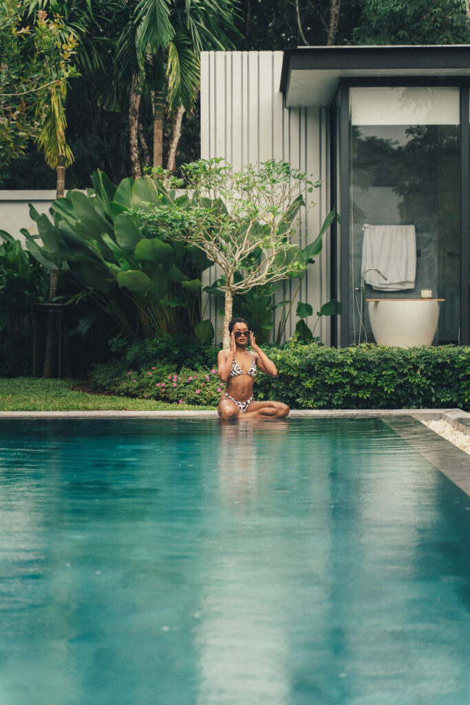 Woman seated by the poolside during a light rainy moment