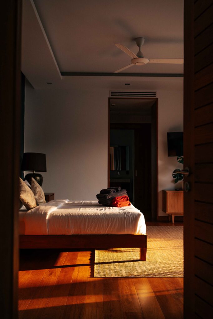 Suite bedroom partially visible with soft light falling on the bed linens